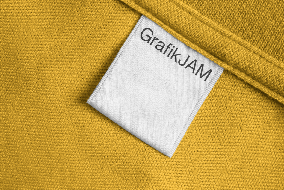 Mustard yellow garment with white woven label showing Grafik JAM brand text