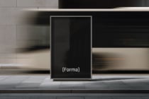 Blank portrait display stand in minimalist storefront with concrete tile floor