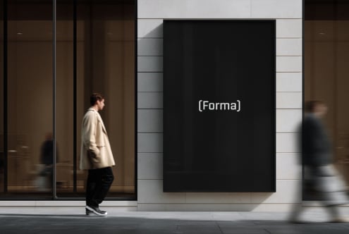 Black billboard mockup on modern storefront with man in beige coat walking by