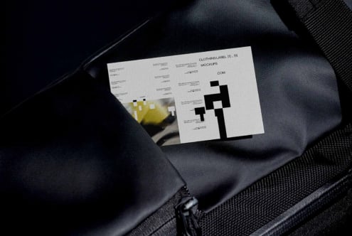 Clothing label mockups spread on dark fabric showing white layout templates with black design elements