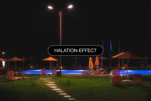 Illuminated poolside scene at night showing warm halation effect on landscape