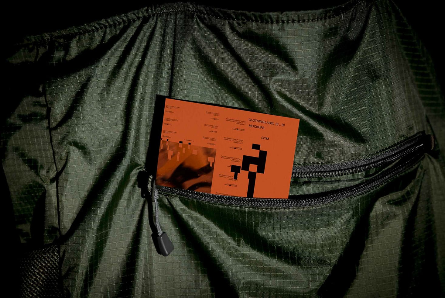 Orange clothing label mockup card inside open green jacket pocket