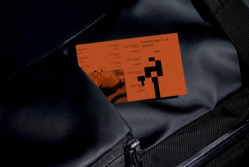 Orange clothing label mockup folded on dark navy fabric with geometric cutout