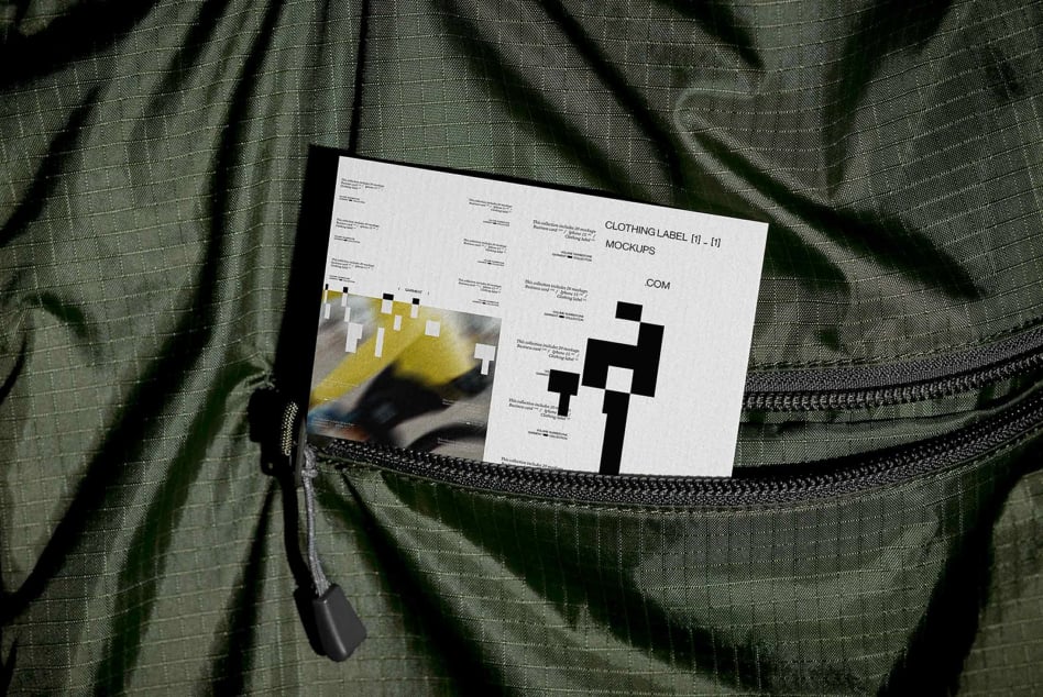 White clothing label mockup card inside open green jacket pocket
