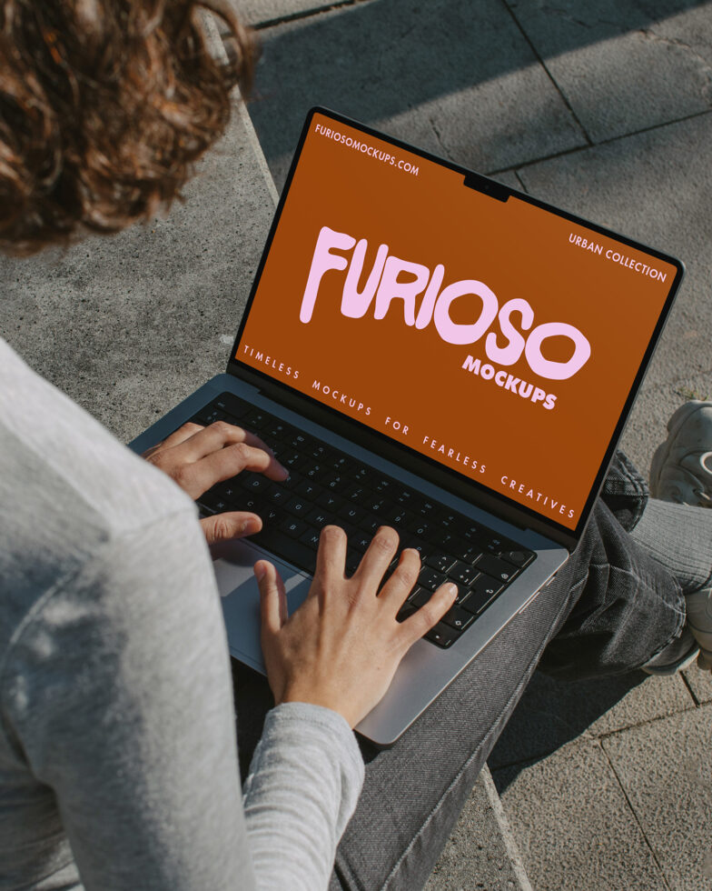 Person typing on laptop showing orange Furioso Mockups design on screen