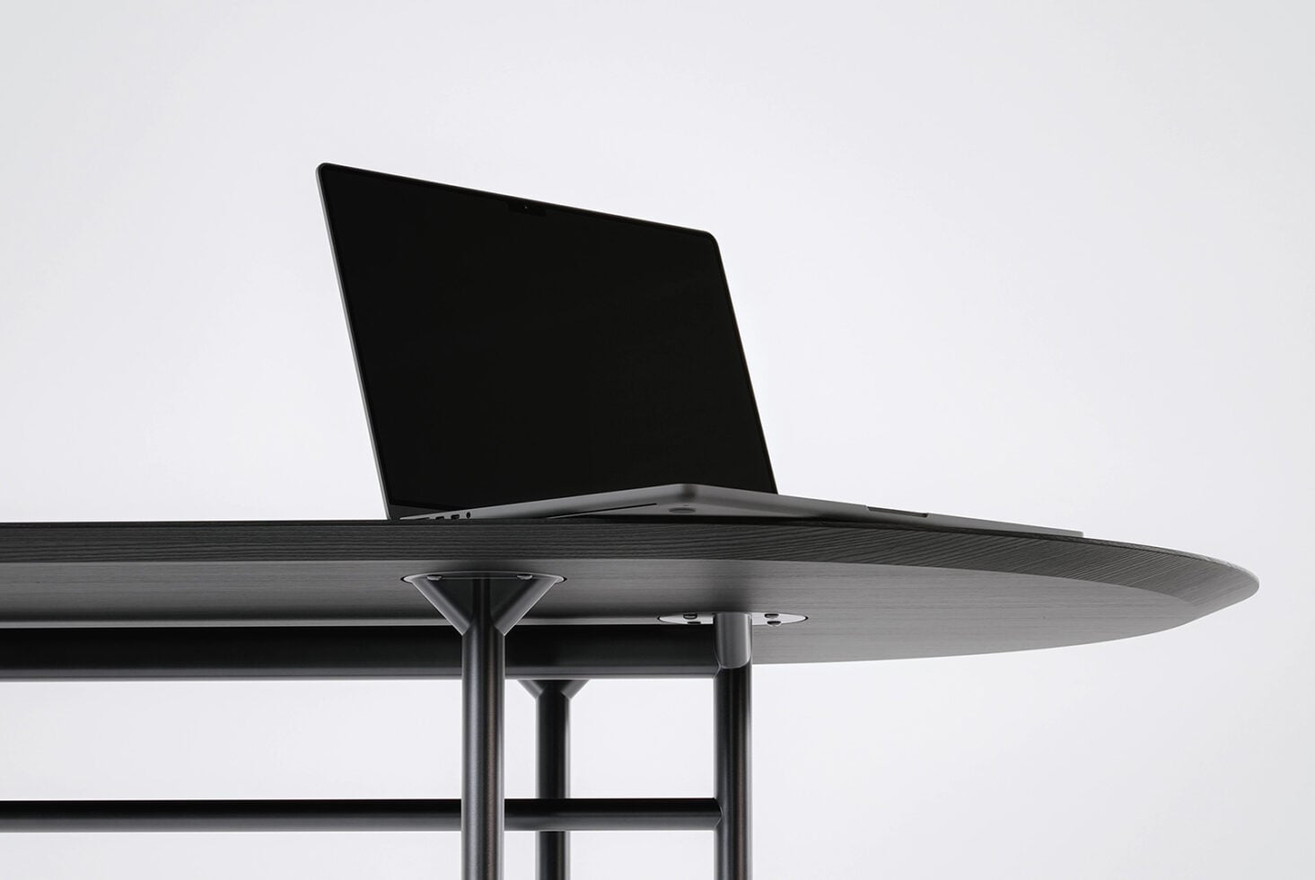 Laptop on round table with liquid metal pattern displayed on screen