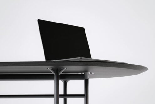 Laptop on round table with liquid metal pattern displayed on screen