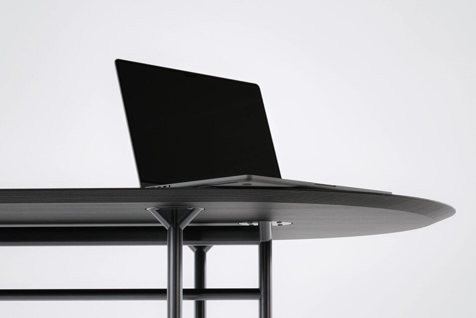 Laptop on round table with liquid metal pattern displayed on screen