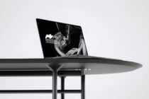 Side angle of blank macbook on contemporary dining setup