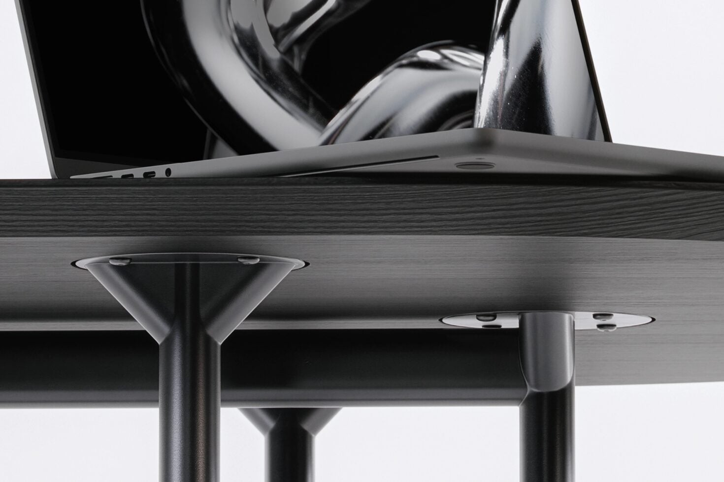 Overhead view of open laptop on wooden table with metal legs
