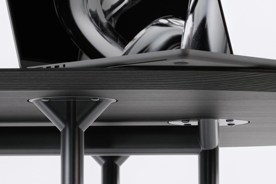 Overhead view of open laptop on wooden table with metal legs