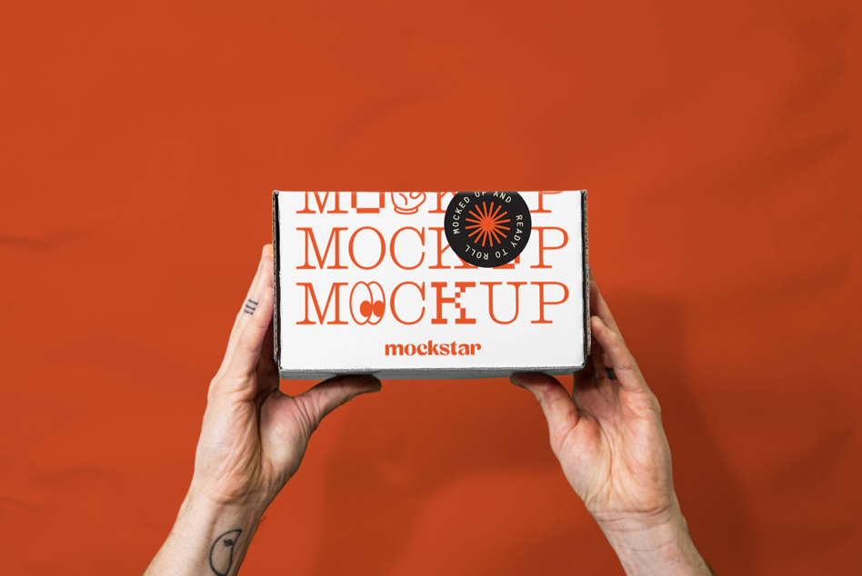 Hands holding small white box with orange text mockup on red background