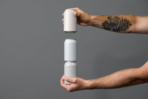 Two hands holding stacked blank grid cans in minimalist gray studio setup