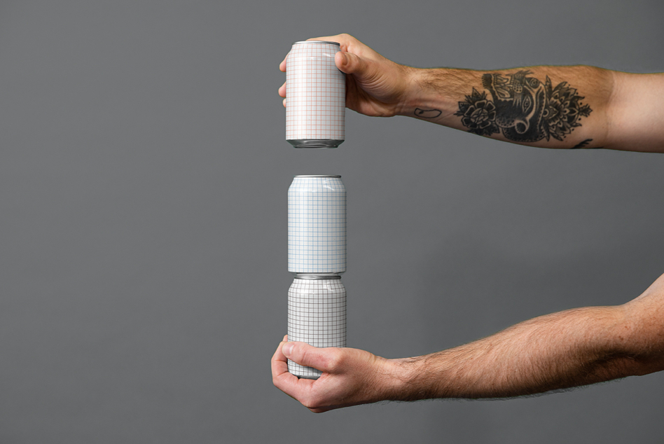 Two hands holding stacked blank grid cans in minimalist gray studio setup