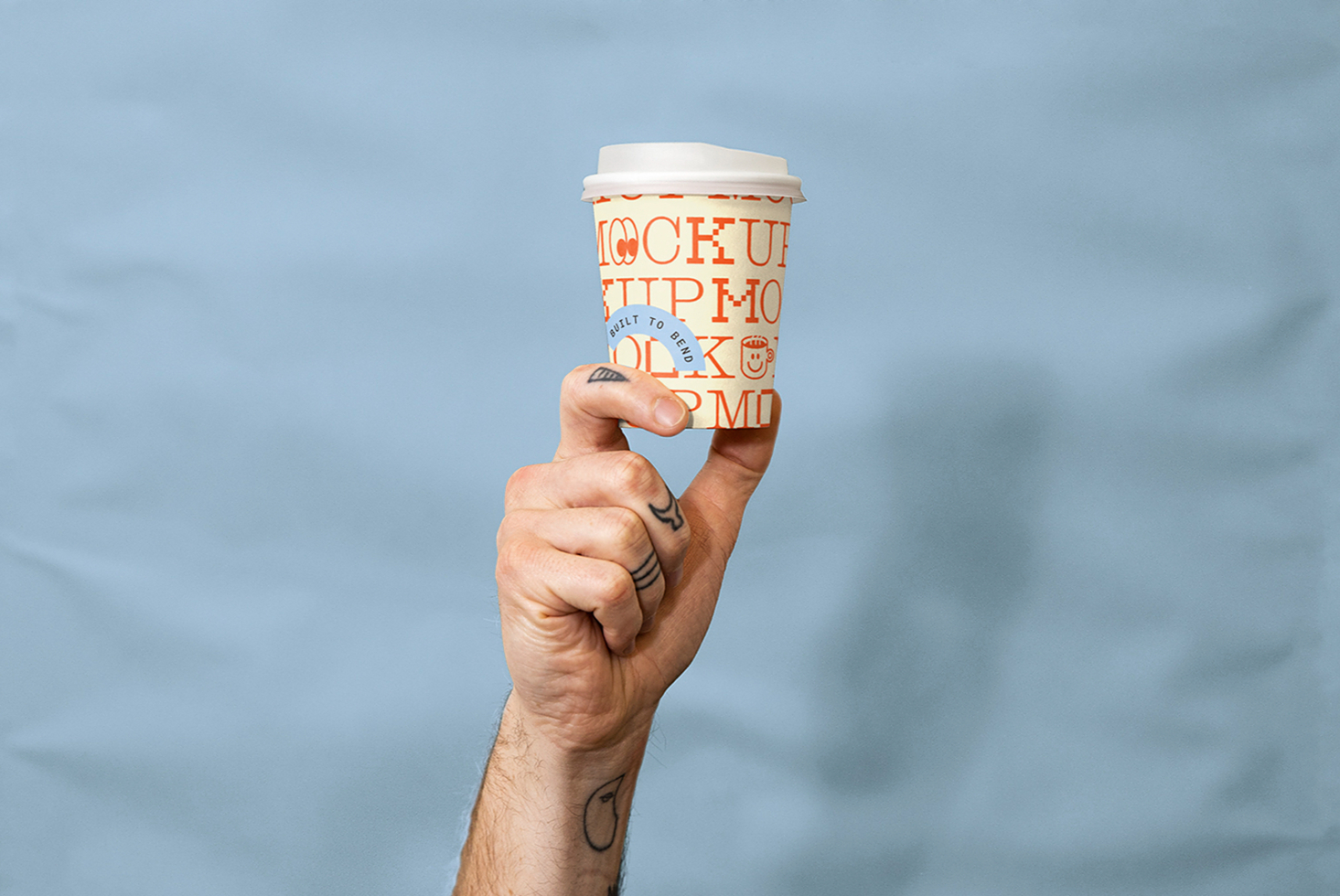 Hand holding branded coffee cup with orange text mockup against sky backdrop