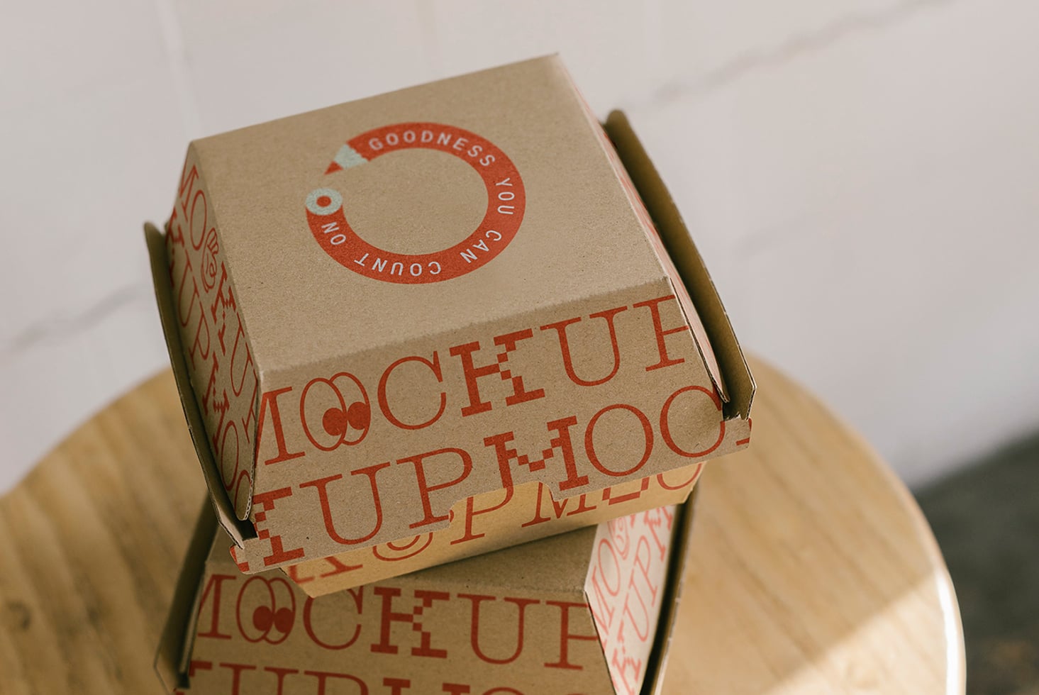 Custom printed cardboard boxes stacked on wooden chair mockup