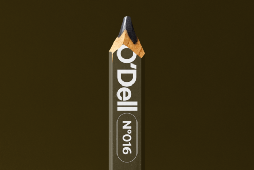 Wooden pencil mockup with O'Dell branding label against olive textured backdrop