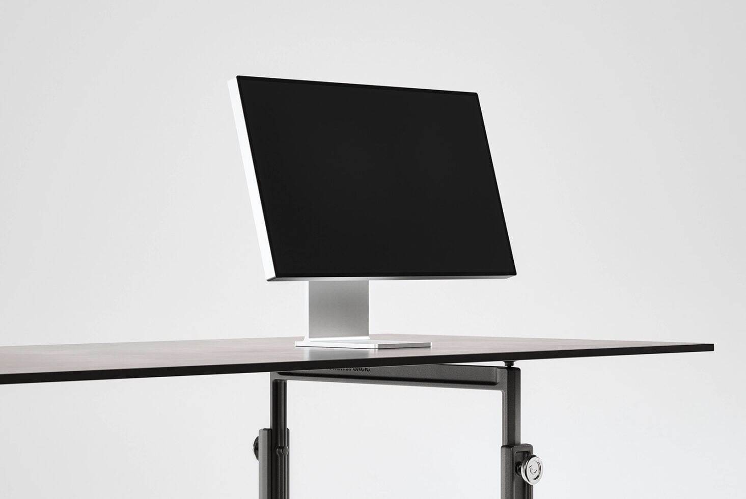 Modern monitor on pedestal base with blank black screen ready for mockup content