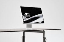 Monitor displaying fashion portrait with Forma branding on stand in studio setup