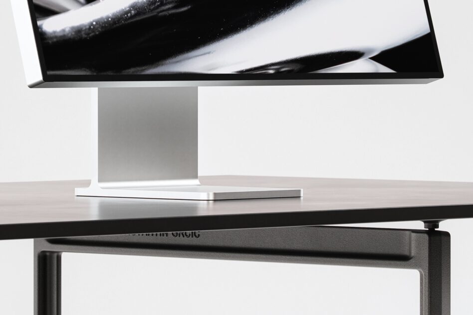 Desktop monitor on stand with adjustable arm showing abstract black brushstroke on screen