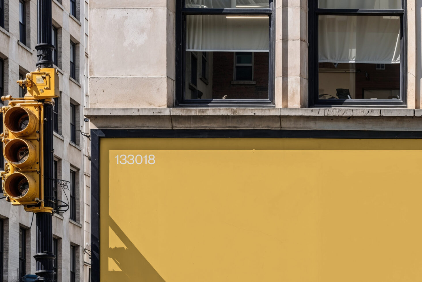 Yellow storefront awning with white numbers, traffic light visible on city street