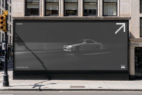 Large storefront billboard showing grayscale sports car with white pixel arrow