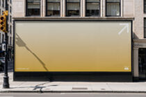 Storefront billboard with soft peachy gradient background displaying white pixel arrow