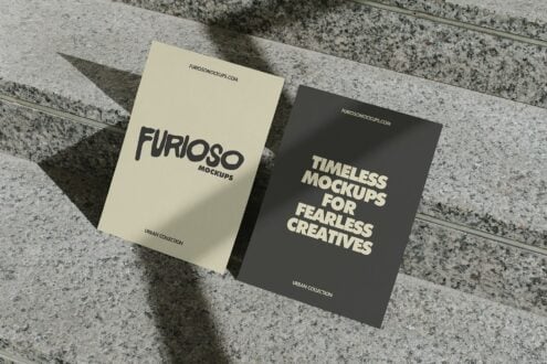 Cream white postcard next to dark charcoal postcard leaning on concrete steps