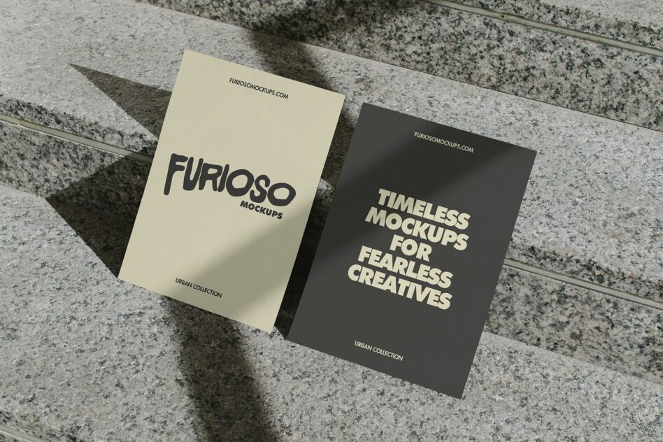 Cream white postcard next to dark charcoal postcard leaning on concrete steps