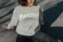 Person in light gray sweatshirt with cream Furioso lettering from above