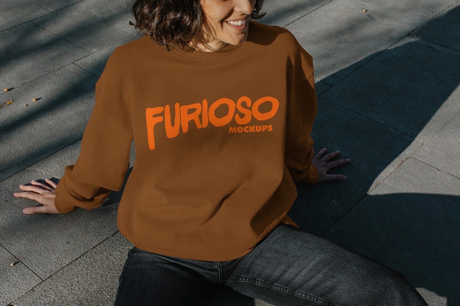 Overhead shot of person in caramel crewneck with orange Furioso logo