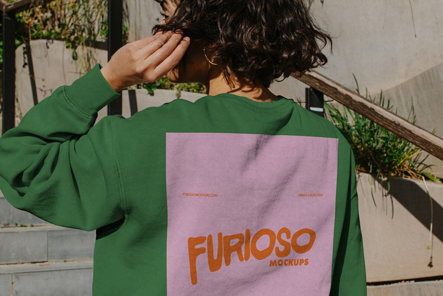 Outdoor shot of green sweatshirt with pink back graphic detail