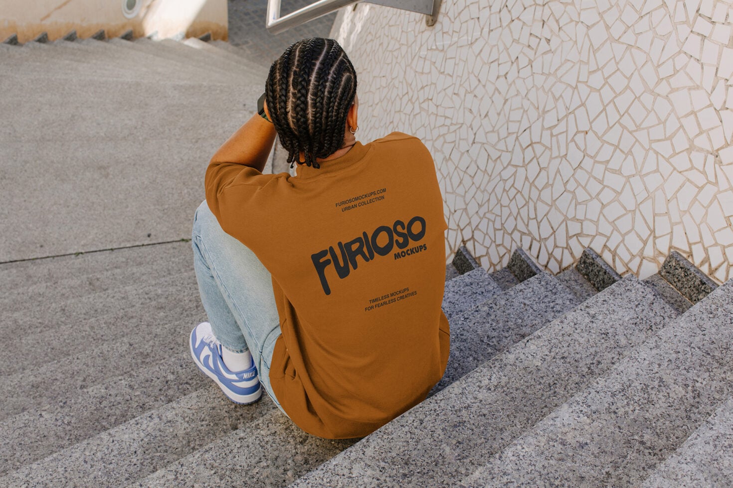 Overhead shot of person crouching in orange sweatshirt back view