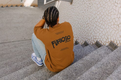 Overhead shot of person crouching in orange sweatshirt back view