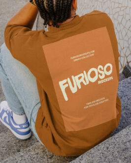 Person wearing burnt orange sweatshirt showing back print design