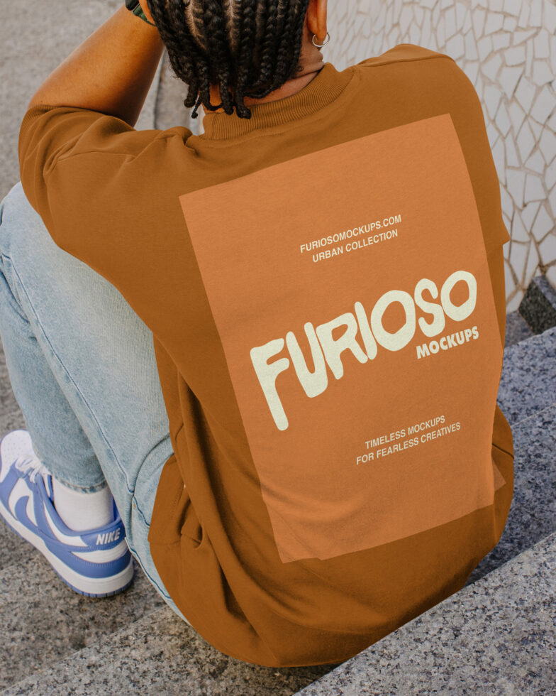 Person wearing burnt orange sweatshirt showing back print design