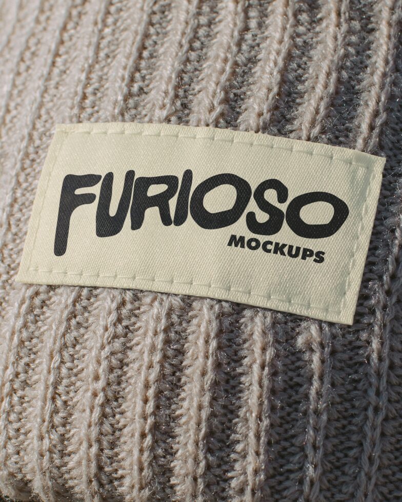 Cream woven label with black Furioso print on beige cable knit sweater