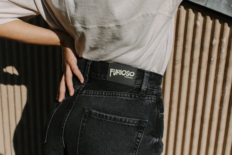 Black woven label with white Furioso branding clipped to dark denim waist
