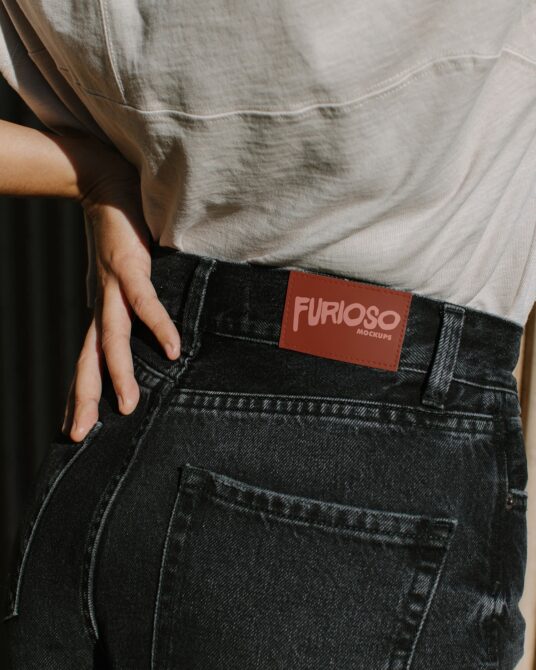 Rust colored tag with pink Furioso lettering on black jeans waistband
