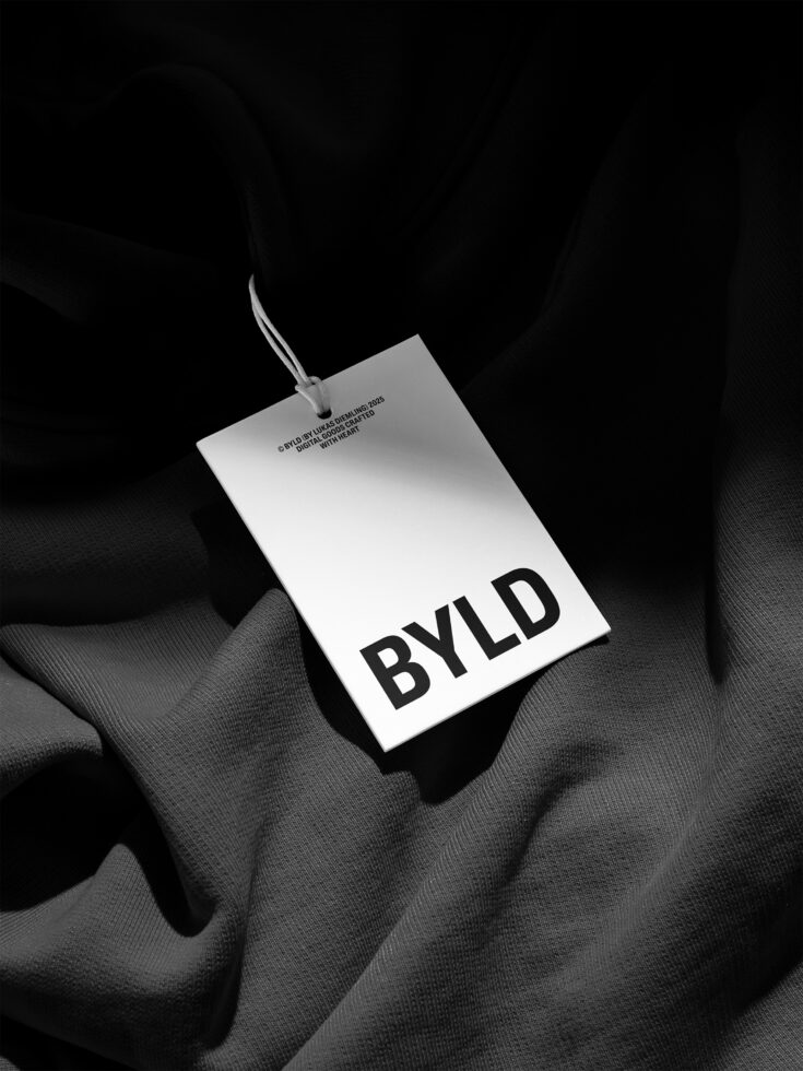 White rectangular hang tag with BYLD text on gray fabric