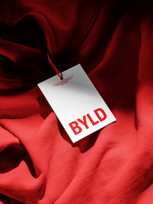 White hang tag with red BYLD text on crimson red fabric