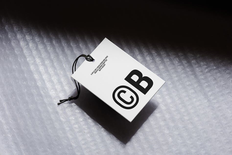 White hang tag mockup with black logo on textured concrete surface