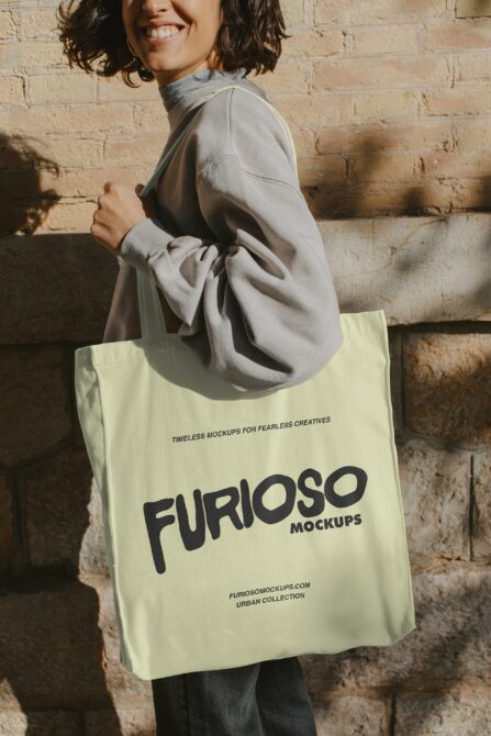 Person holding pale yellow tote bag with bold FURIOSO logo in black text