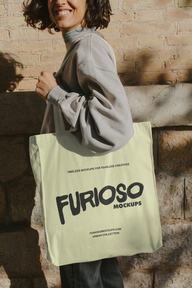 Person holding pale yellow tote bag with bold FURIOSO logo in black text