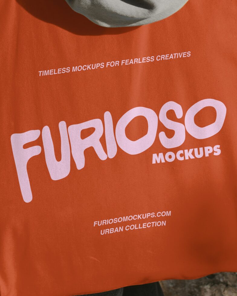 Orange tee with pink branding text, hat detail visible at top