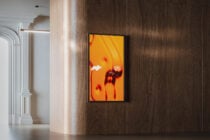 Portrait frame mockup with neon red bow graphic displayed on wooden interior wall