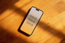 iPhone with golden gradient display showing repeated Japanese typography