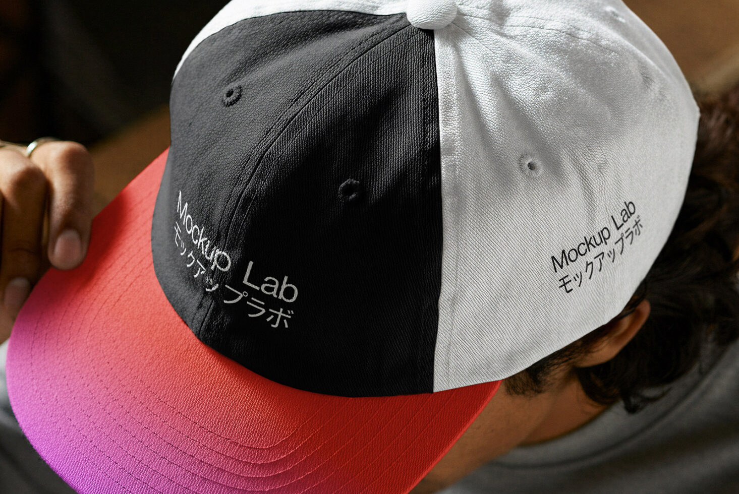 Snapback cap showing split color design in white black red with embroidered text