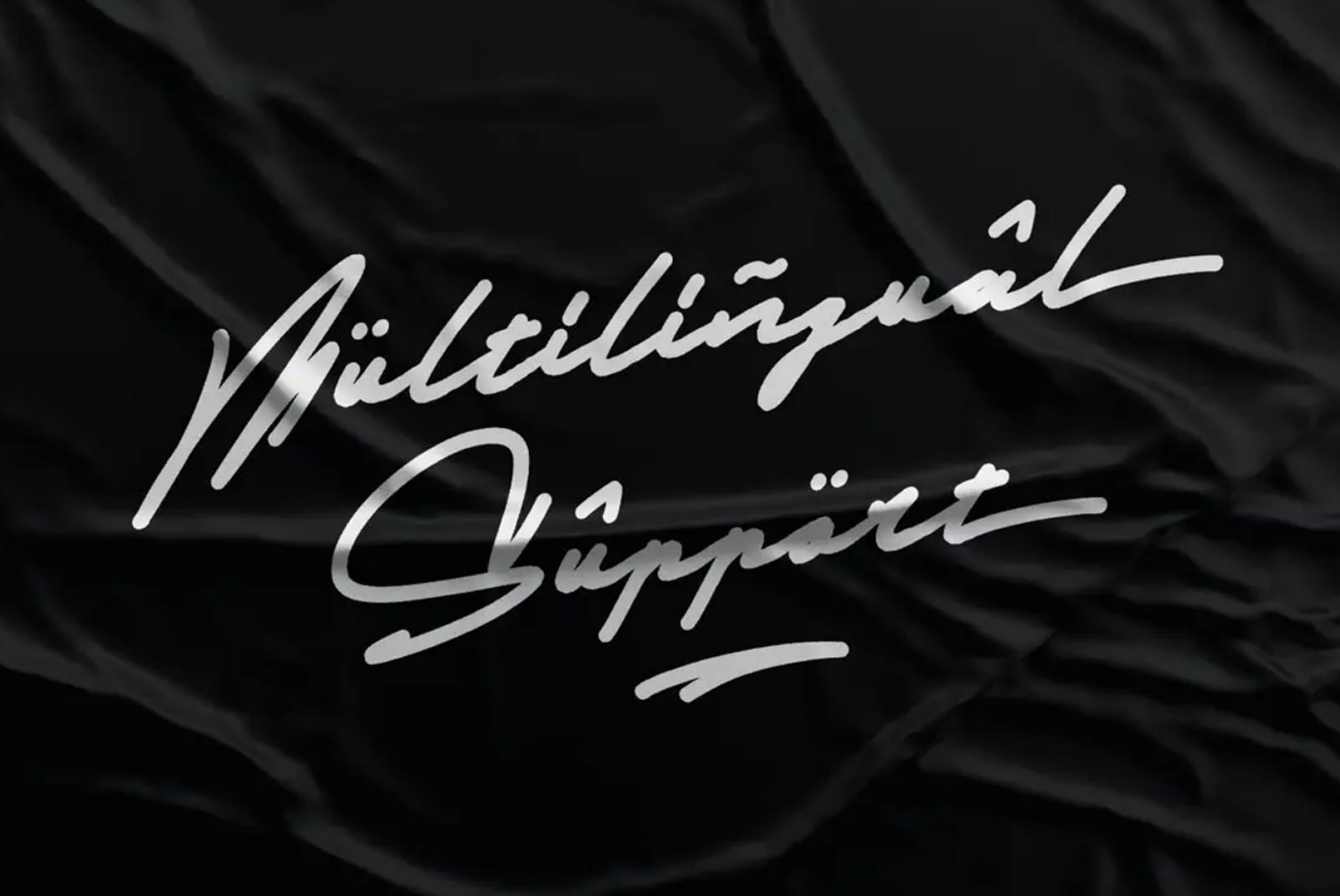 Multilingual Support text in flowing script on wrinkled black fabric