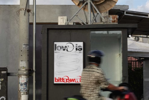 Poster mockup on dark storefront showing love is bitter sweet design